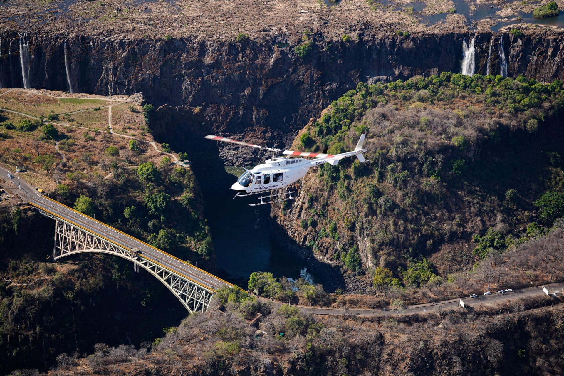 Helicopter banking over the full curtain of Victoria Falls.
